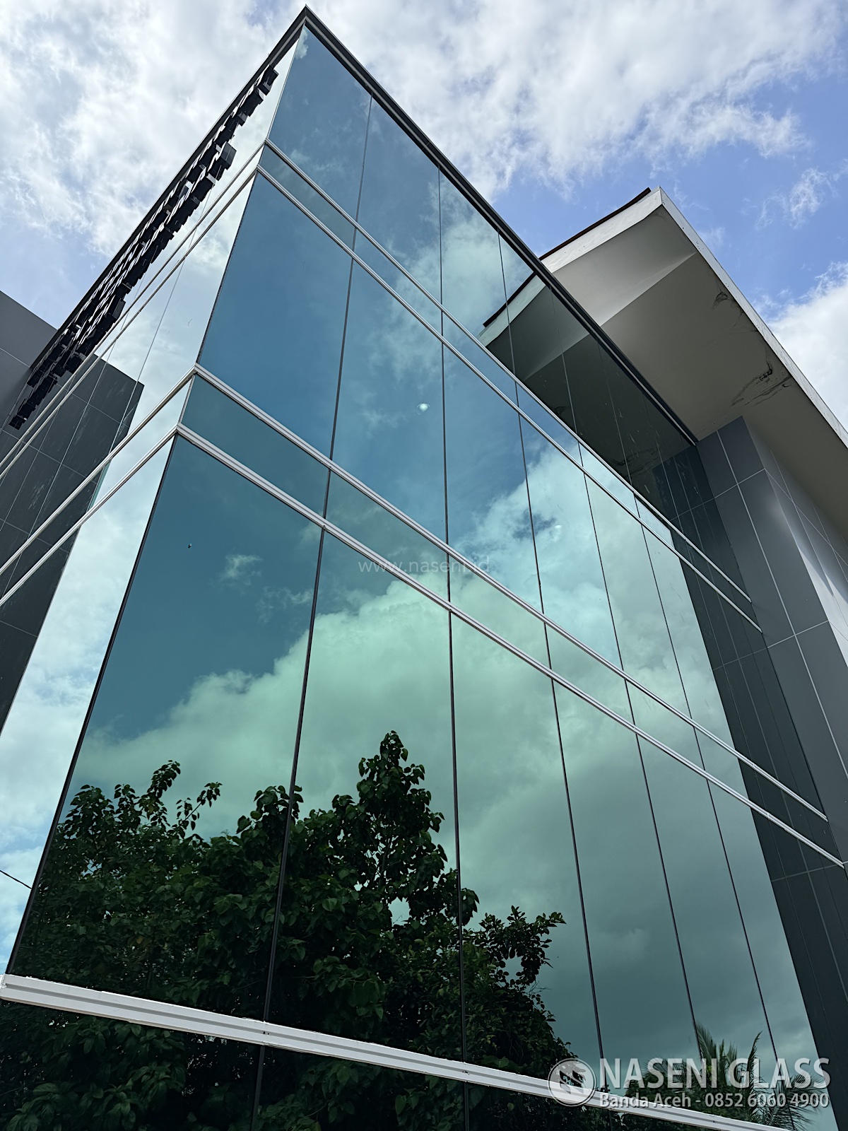 Tampilan sudut bangunan Gedung PERKIM Aceh dengan curtain wall kaca reflektif